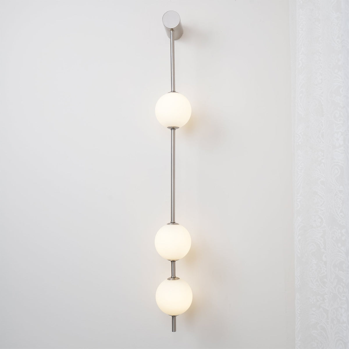 Soloiella wandlamp met verticale bollen van messing