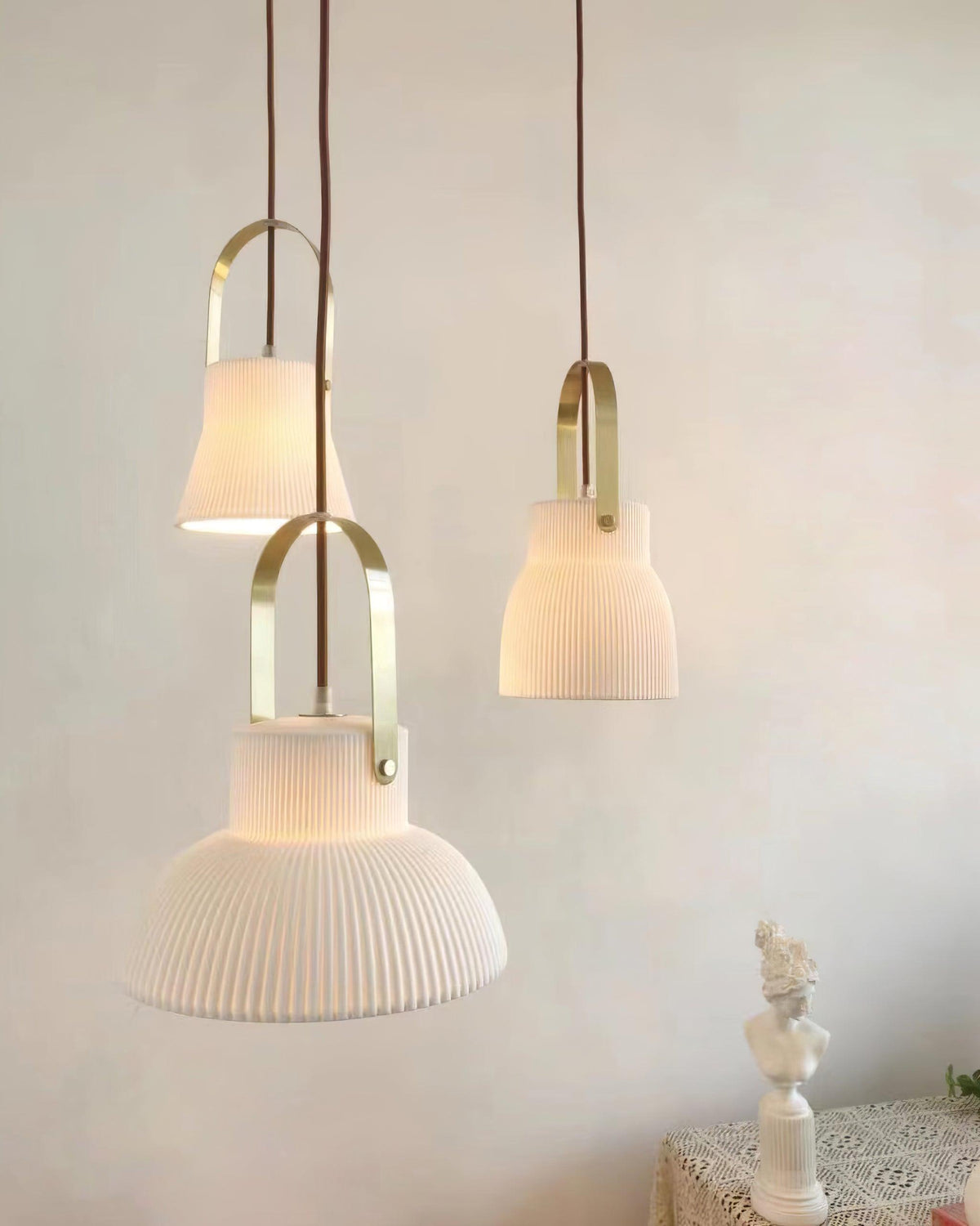 Hanglamp met ribbelstructuur in wit keramiek en messing handvat