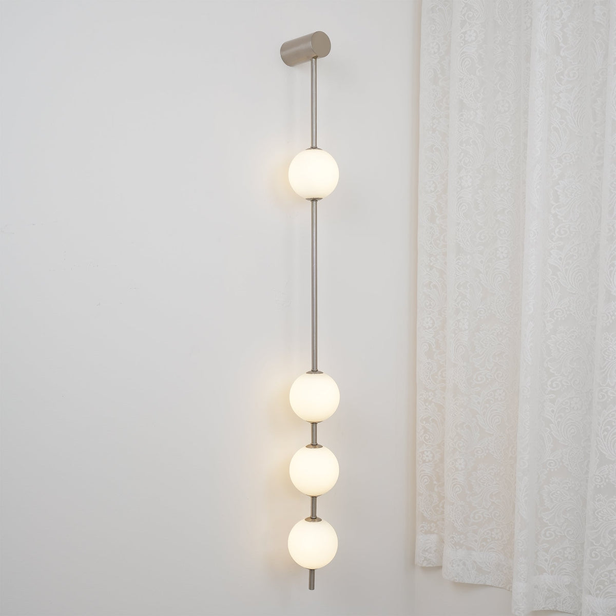 Soloiella wandlamp met verticale bollen van messing