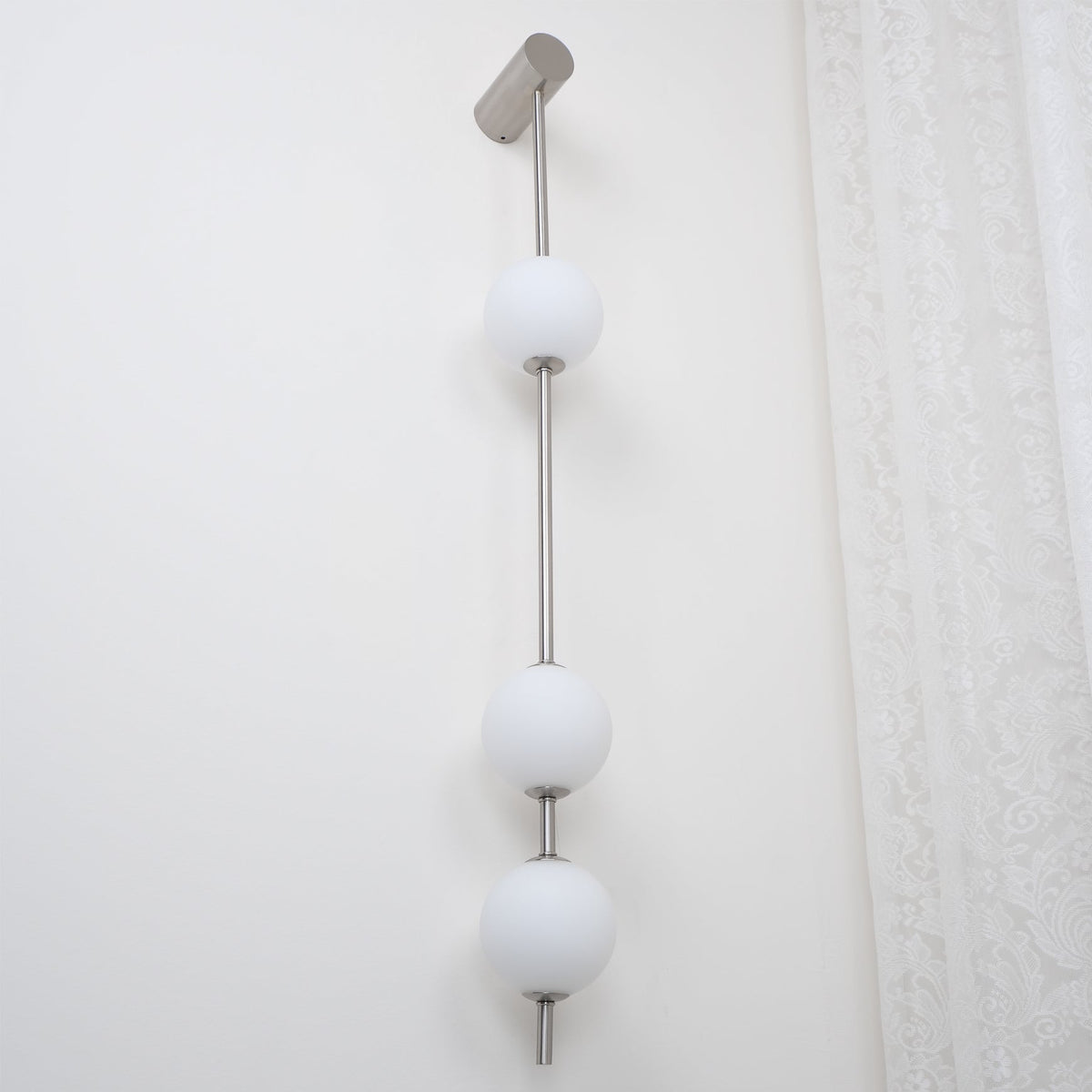 Soloiella wandlamp met verticale bollen van messing